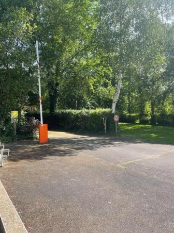 un parking vide avec un panneau d'arrêt et des arbres dans l'établissement Camping Onlycamp le Clos Imbert, à Thouars