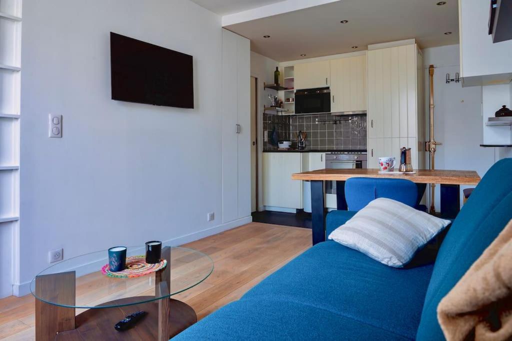 un salon avec un canapé bleu et une table dans l'établissement Appartement moderne proche Gare de Lyon, à Paris