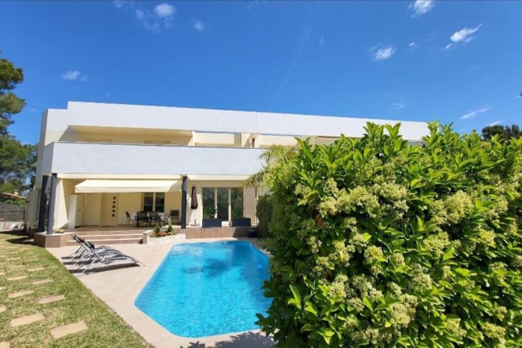 a house with a swimming pool in front of it at Vistamar in Les tres Cales