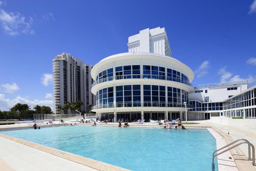 um grande edifício com uma piscina em frente em New Point Miami Beach Apartments em Miami Beach