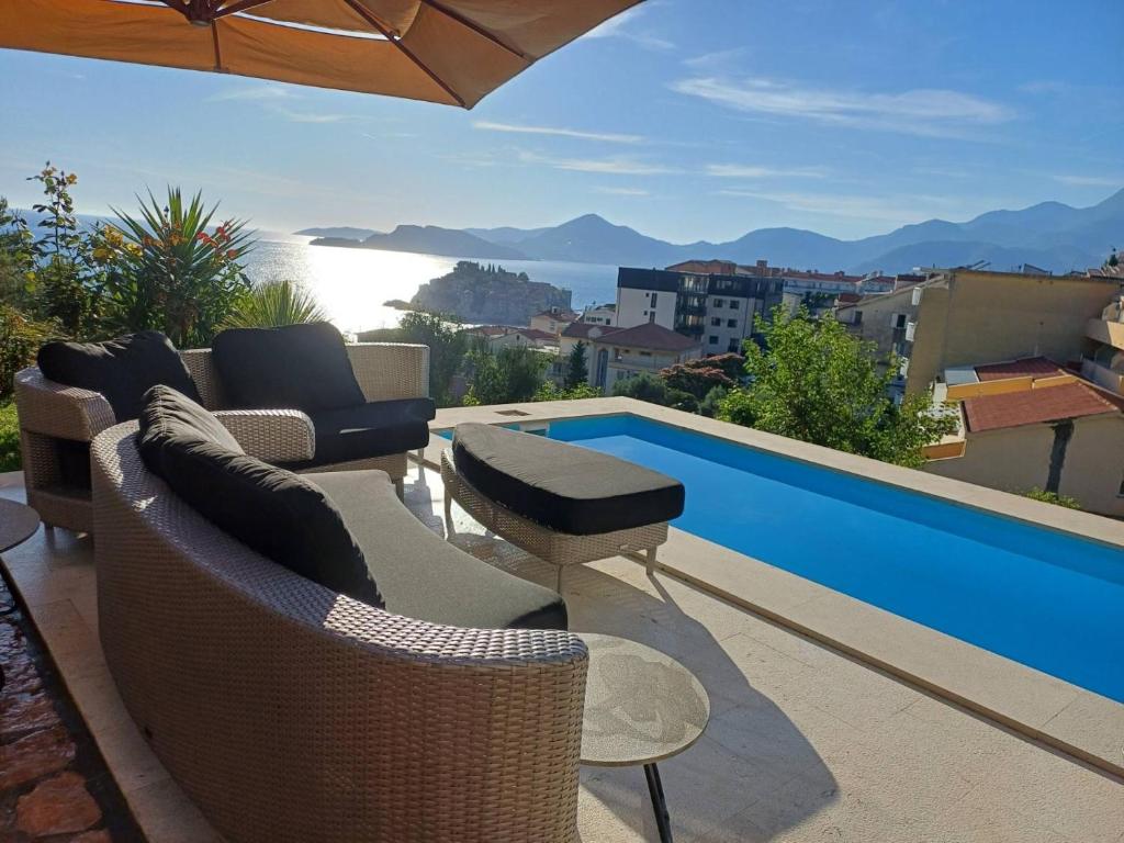 a patio with furniture and a view of a swimming pool at Lux Apartment Luna in Sveti Stefan