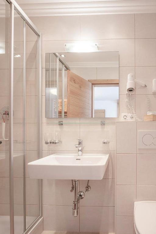biała łazienka z umywalką i prysznicem w obiekcie Appartements Zirmhof w mieście Vent