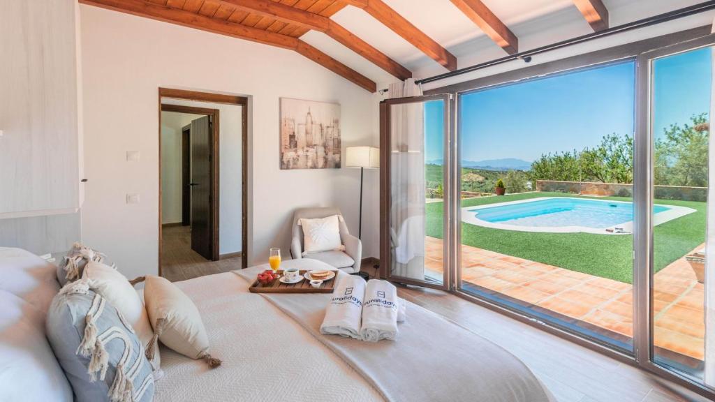 a bedroom with a bed and a view of a pool at Alma del Tejar Antequera La Higuera by Ruralidays in Antequera