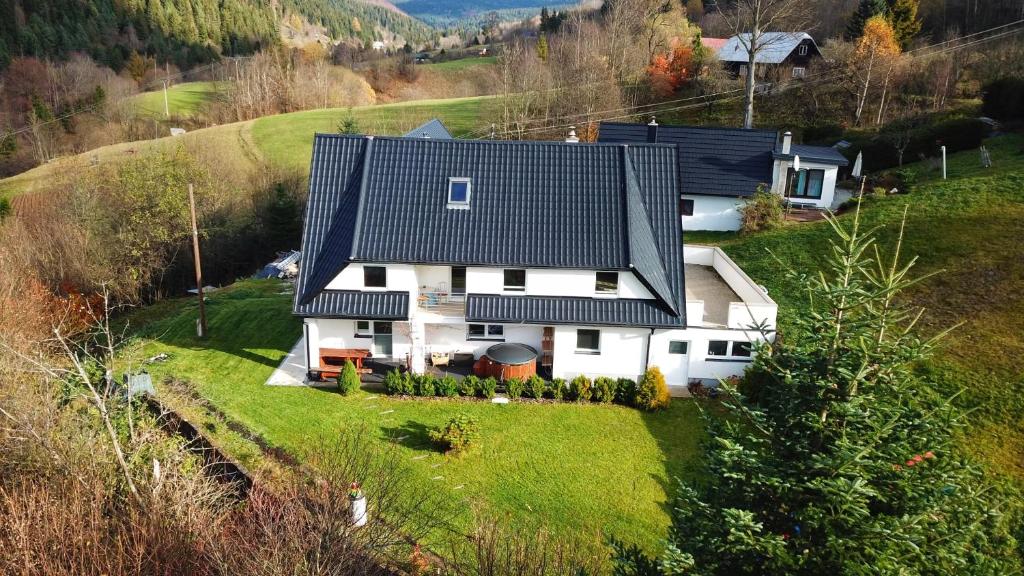 a white house with a black roof on a hill at Chalupa u Vojvodovcov in Zázrivá