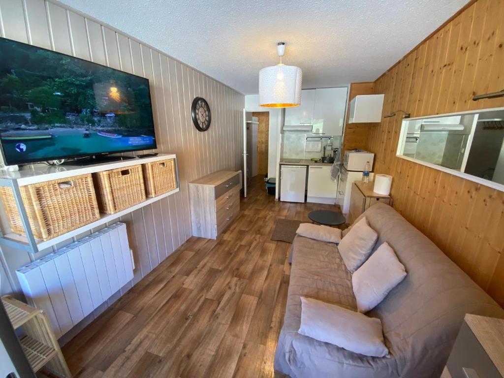 un salon avec un canapé et une télévision à écran plat dans l'établissement La casa de la foux a proximité des pistes vue montagne 6 personnes Max, à Allos