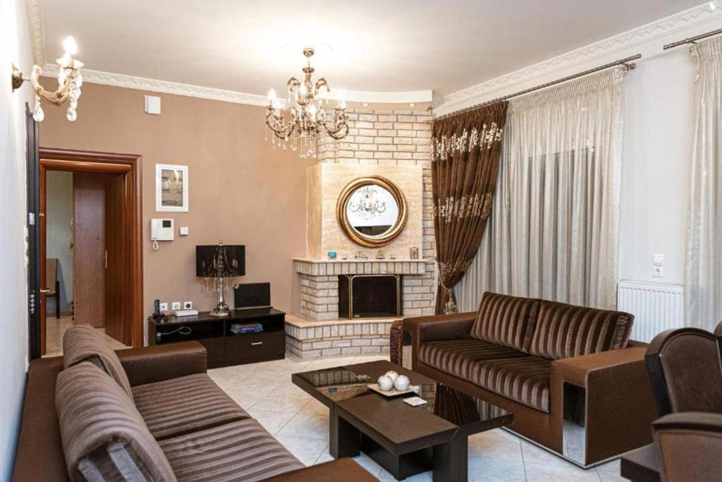 un salon avec un canapé et une cheminée dans l'établissement Vosinakis House in Volos, à Vólos