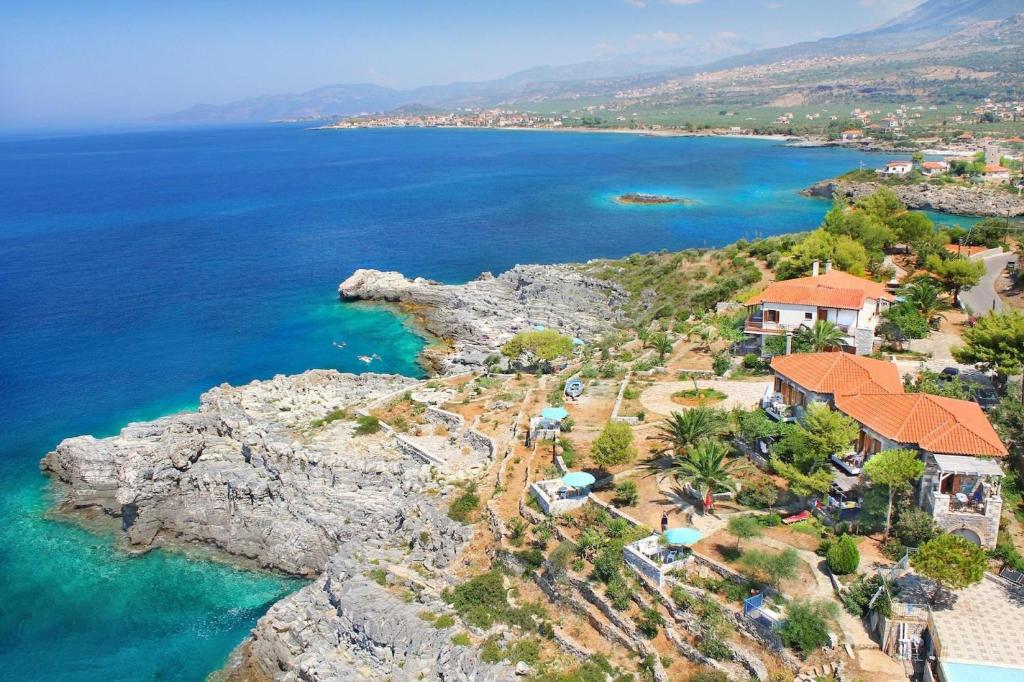 an aerial view of a villa on a rocky coast at Mani Apartments in Agios Nikolaos