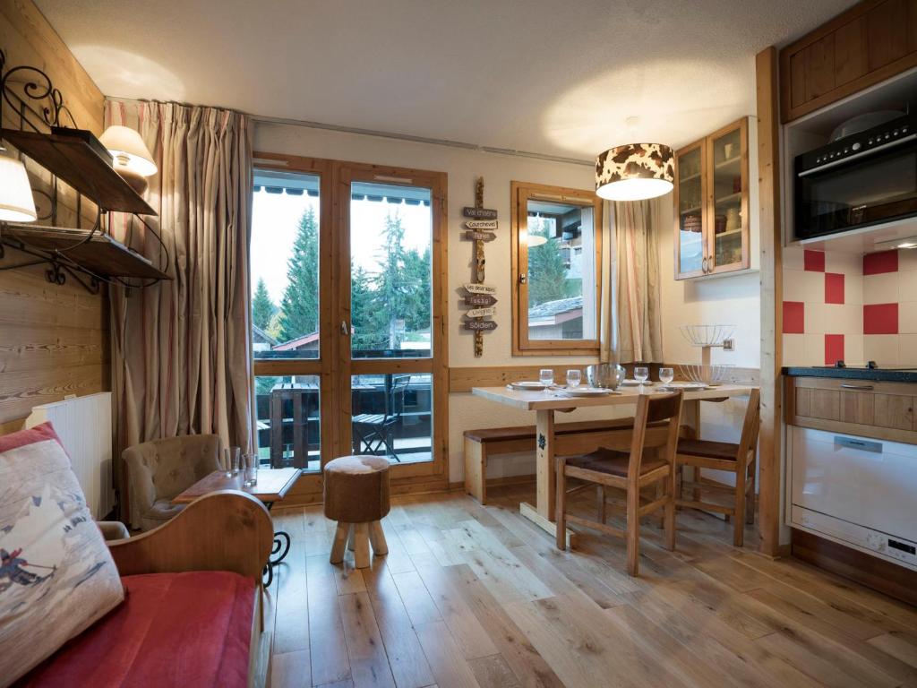 une cuisine et une salle à manger avec une table et des chaises dans l'établissement Charmant 2 pièces rénové à Courchevel avec balcon et Wifi - FR-1-575-27, à Courchevel