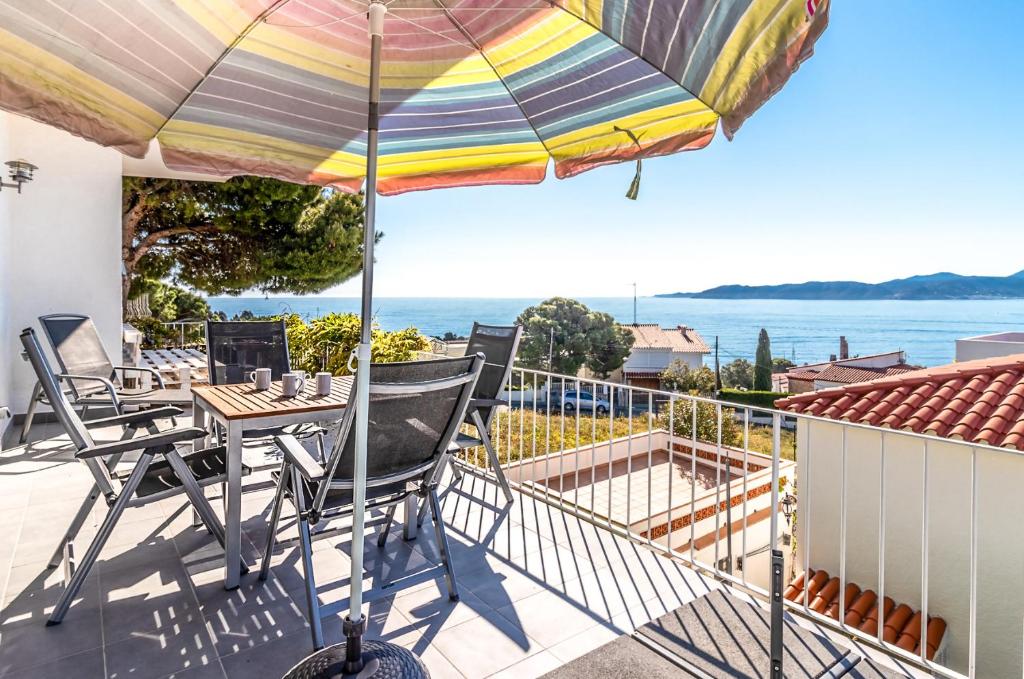 a patio with a table and an umbrella at Cap Ras 01 Apartamento con terraza y vistas in Girona