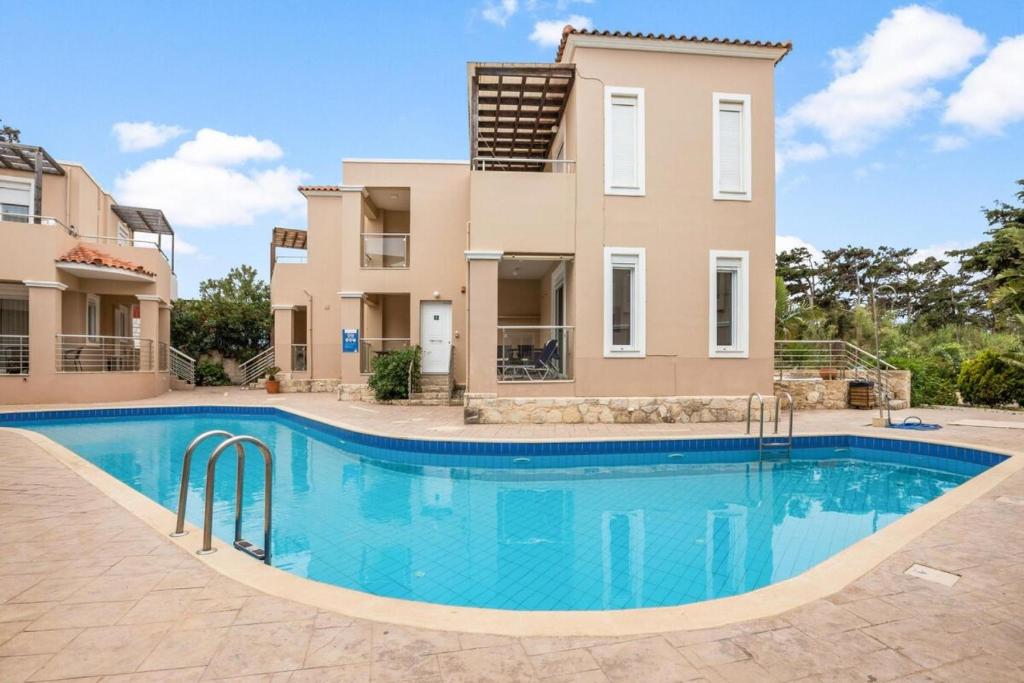 a villa with a swimming pool in front of a house at Villa Blue Dreams in Maleme in Ayiá