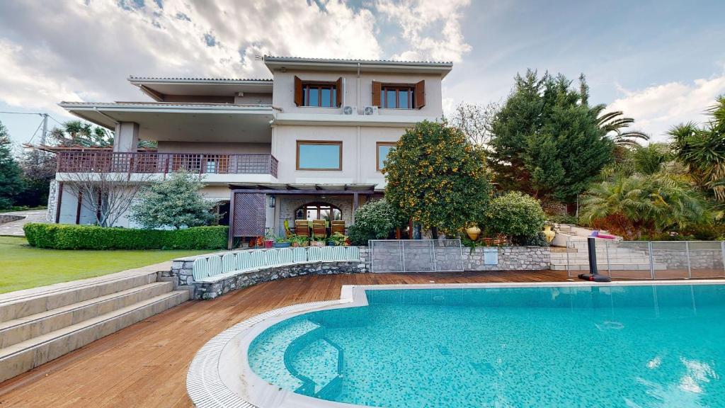 a house with a swimming pool in front of a house at Panorama Villa Sea view in Selianitika