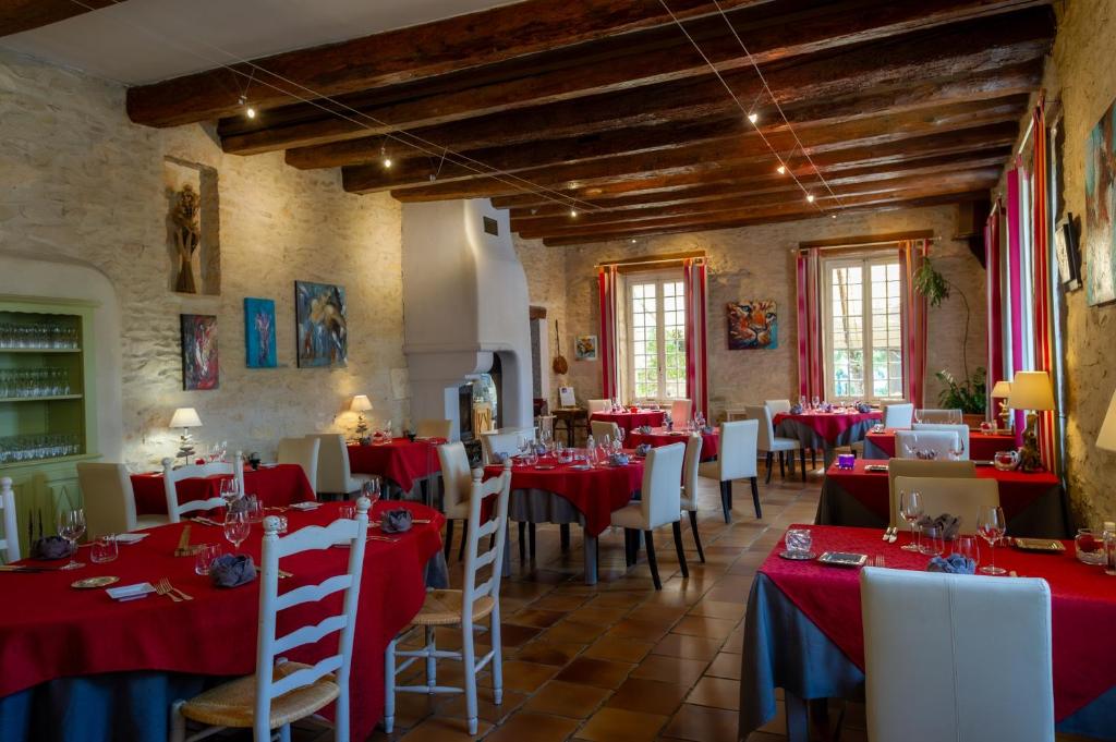 een eetkamer met rode tafels en witte stoelen bij Logis Auberge De Tavel in Tavel