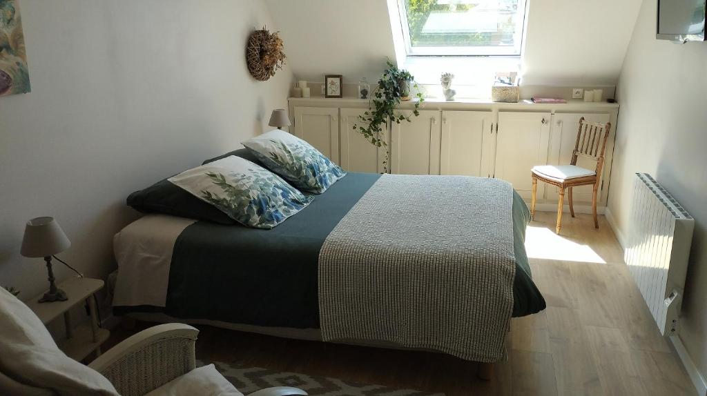 a bedroom with a bed and a kitchen with a window at Le Clos des Mouettes in Calais
