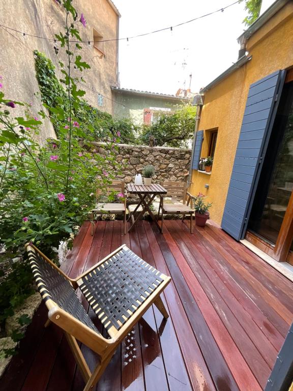 a wooden deck with two chairs and a table at Zofia appartements - Appartement avec cour privée #1 in Moustiers-Sainte-Marie
