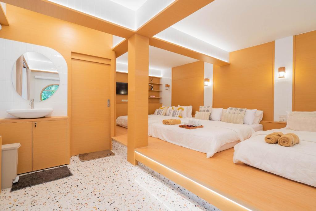 2 łóżka w pokoju z umywalką i lustrem w obiekcie ไชยพล โฮมสเตย์ หมู่บ้านแม่กำปอง w mieście Ban Pok Nai