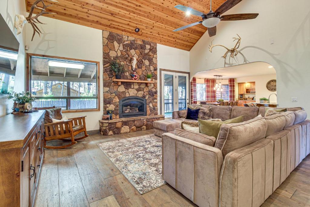 a living room with a couch and a fireplace at Near Woodland Lake Park Cabin with Serene Deck! in Pinetop-Lakeside