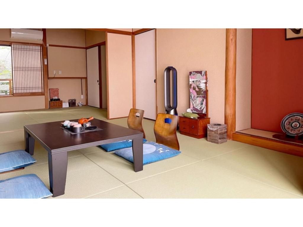 a living room with a table and two chairs at Nagomi no yado Origami - Vacation STAY 80226v in Nagasaki