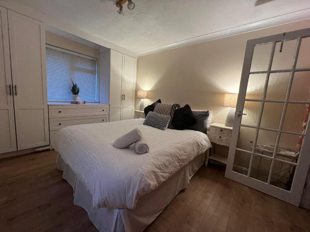 a bedroom with a white bed and a window at Private luxurious apartment in Easthampstead