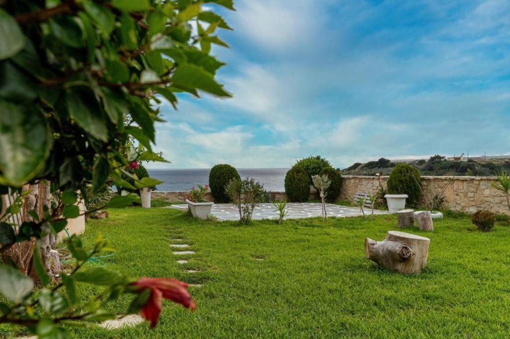 a grassy yard with a view of the ocean at Grand Villa Katerina in Ierápetra