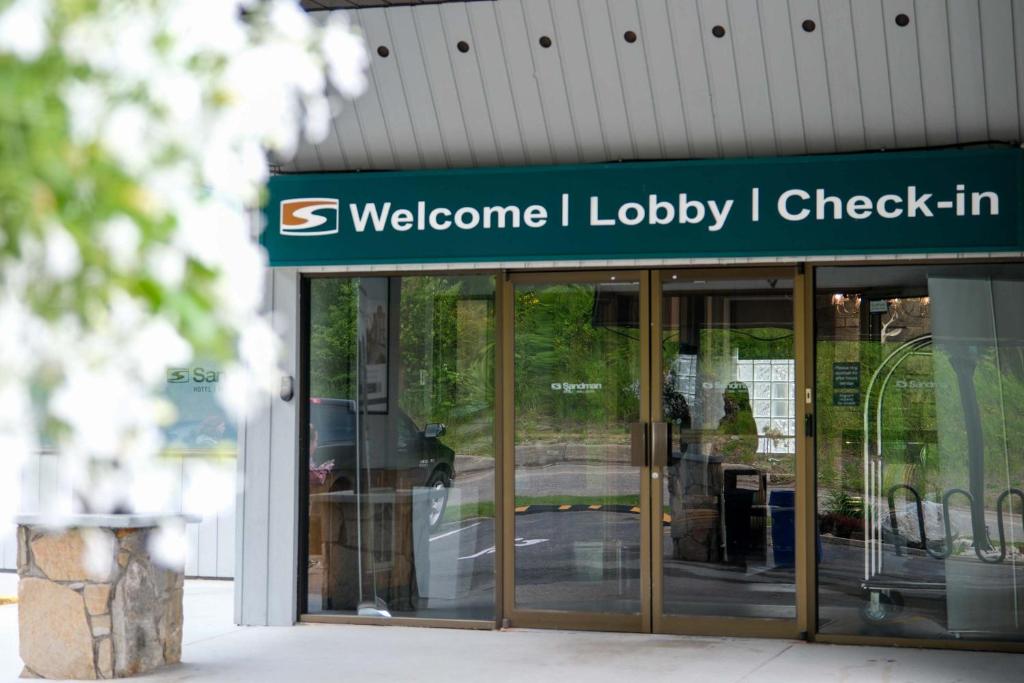 a building with a sign that reads welcome to lobby check in at Sandman Hotel Revelstoke in Revelstoke