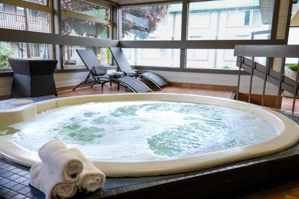 a jacuzzi tub with a towel in a room at Sandman Hotel Revelstoke in Revelstoke