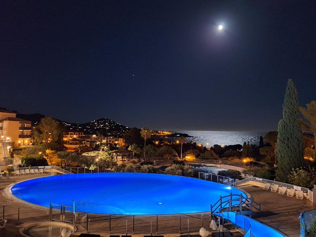 - une grande piscine la nuit avec la lune dans l'établissement CAP SOLEIL J4 appt 124, à Saint-Raphaël