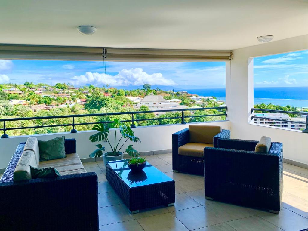 een woonkamer met uitzicht op de oceaan bij Kaili Ocean view luxury 2BR AC throughout Fiber Wifi & Pool in Papeete