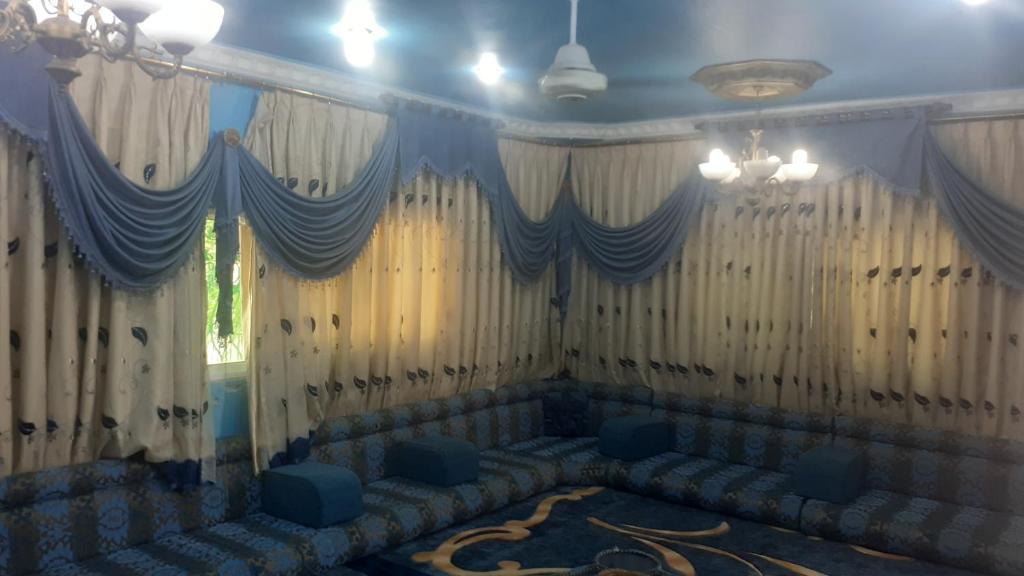 a room with couches and curtains and a chandelier at الاردن اربد الرمثا in Ar Ramthā