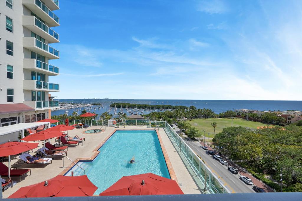- Vistas a la piscina de un complejo con sombrillas rojas en Fabulous 2 bedroom in Heart of Grove, en Miami
