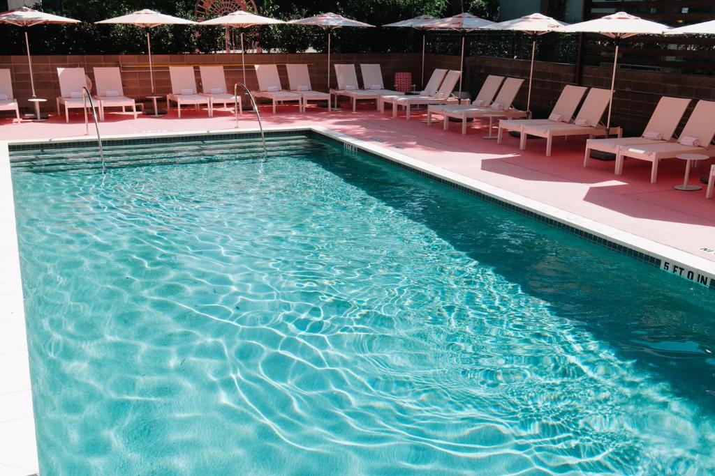 a large swimming pool with chairs and umbrellas at Downright Austin, A Renaissance Hotel - New Hotel in Austin
