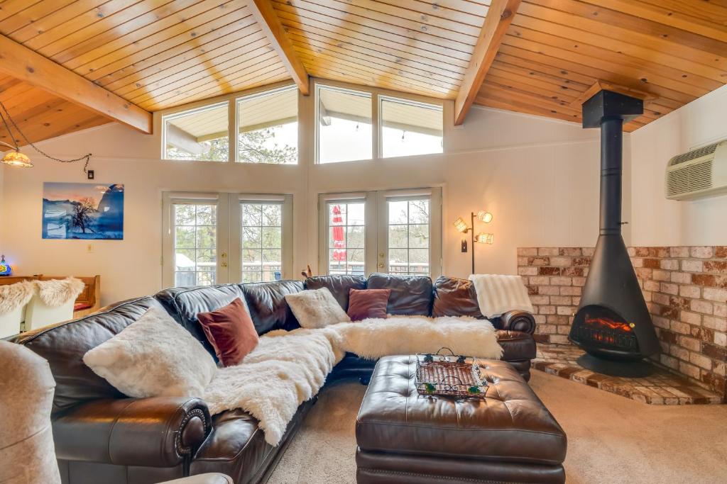 sala de estar con sofá de cuero y chimenea en Cozy Groveland Chalet Near Yosemite!, en Groveland