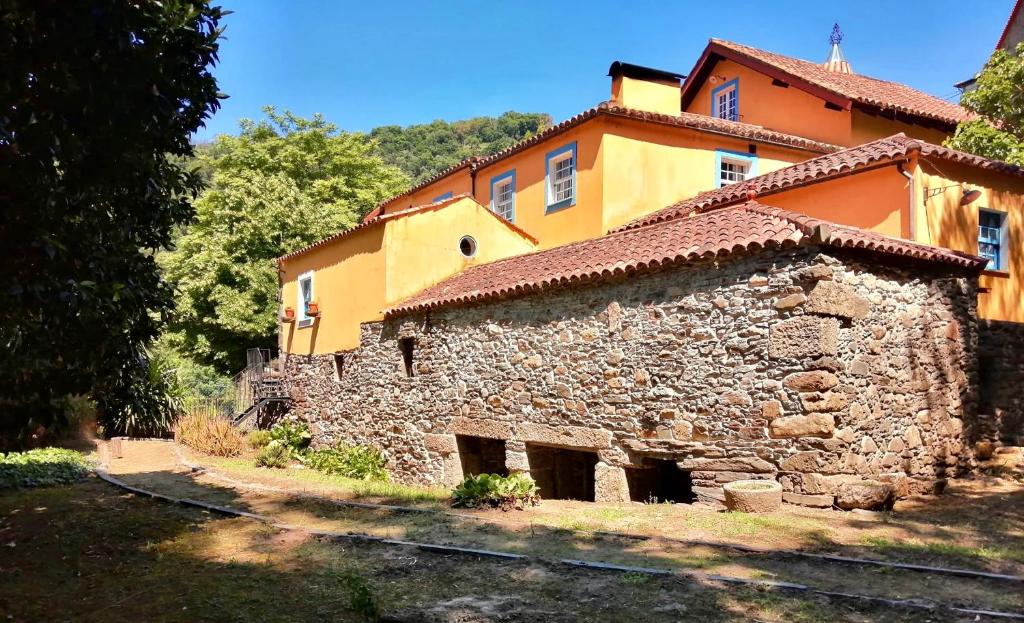 an old stone building with an orange at Moinho do Granjão - Water Mill in Mesão Frio
