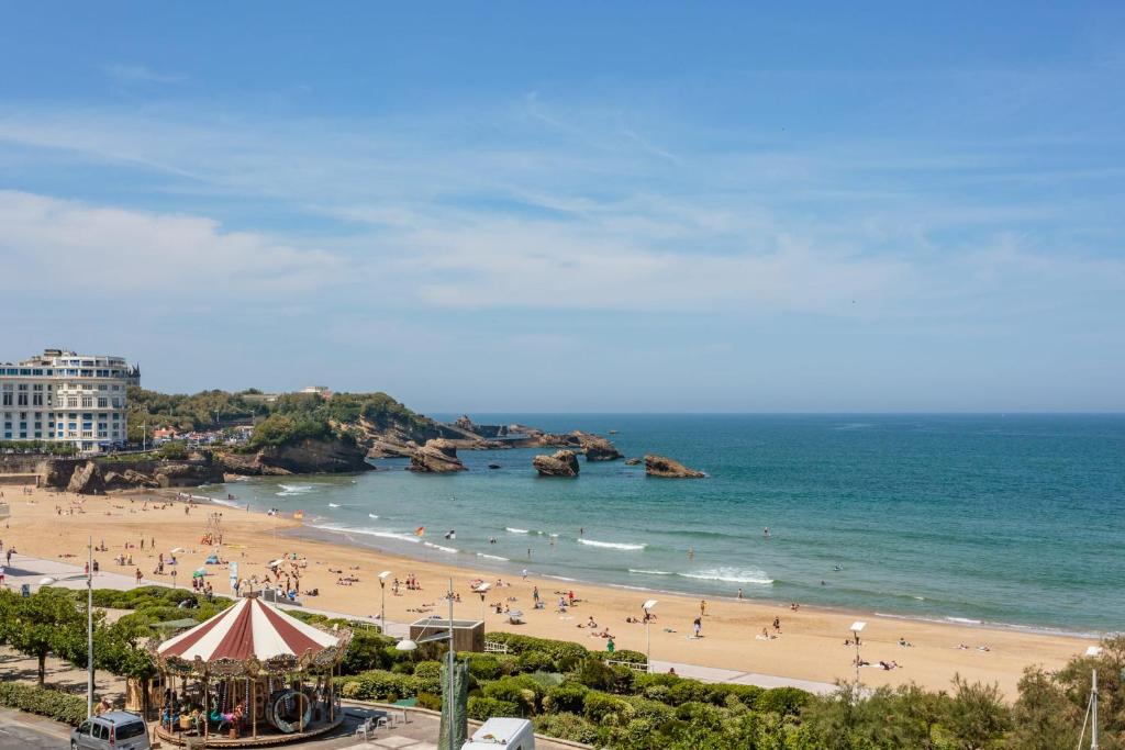 une plage avec beaucoup de gens dans l'eau dans l'établissement Studio Océan vue mer - Welkeys, à Biarritz