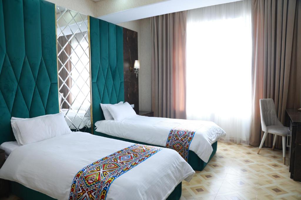 Cette chambre comprend 2 lits et un mur vert. dans l'établissement Hotel Shirin, à Isfara