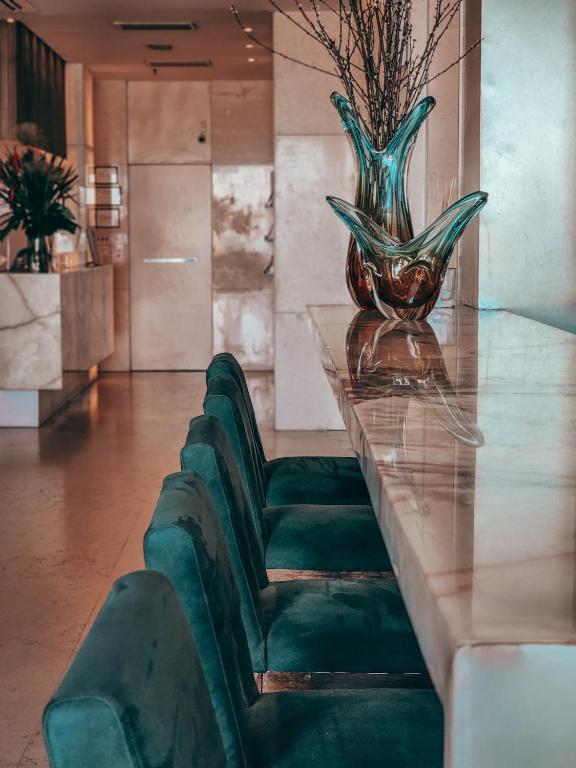 a table with a green chair and a vase on it at Sol Ipanema Hotel in Rio de Janeiro