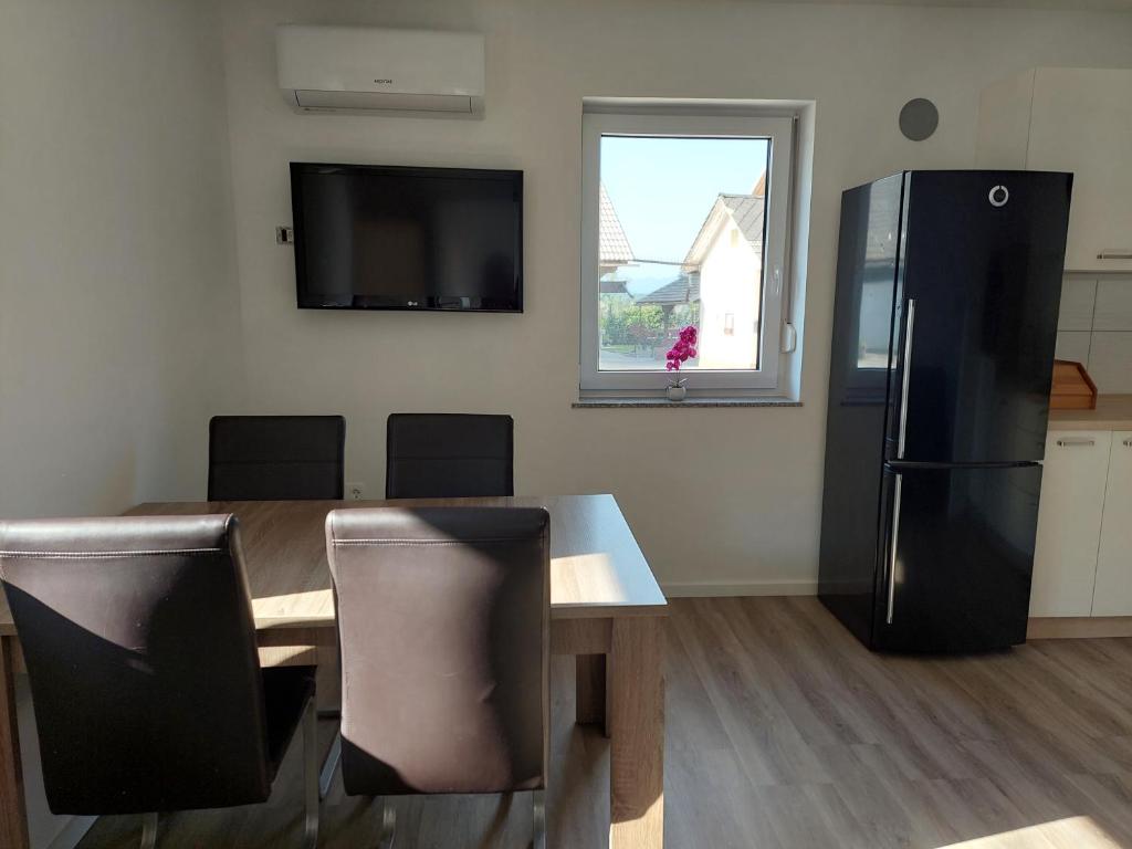 a kitchen with a table and a black refrigerator at Apartment house Petra in Cerklje na Gorenjskem