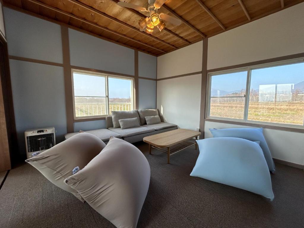 ein Wohnzimmer mit Sofa, Stühlen und Fenstern in der Unterkunft Hinode Land - Vacation STAY 06589v in Kombu