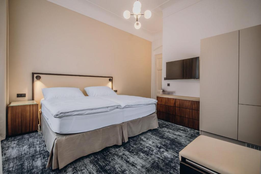 a hotel room with a large bed and a kitchen at Esplanade Carlsbad in Karlovy Vary