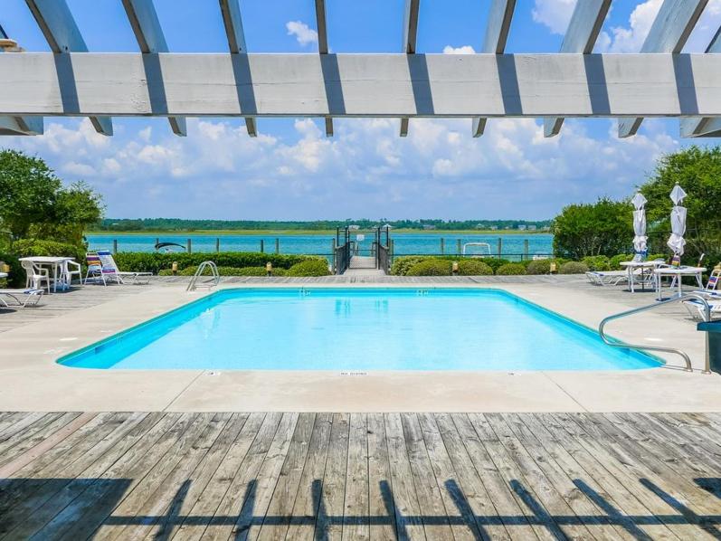 a swimming pool with a view of the water at The Shell Collector in Surf City