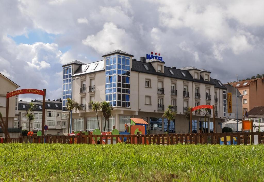 a large building with a grassy area behind it at Hotel Playa de Laxe in Laxe