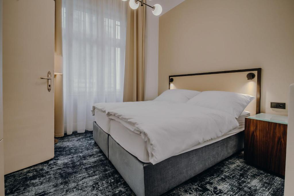 a bedroom with a large bed and a window at Esplanade Carlsbad in Karlovy Vary