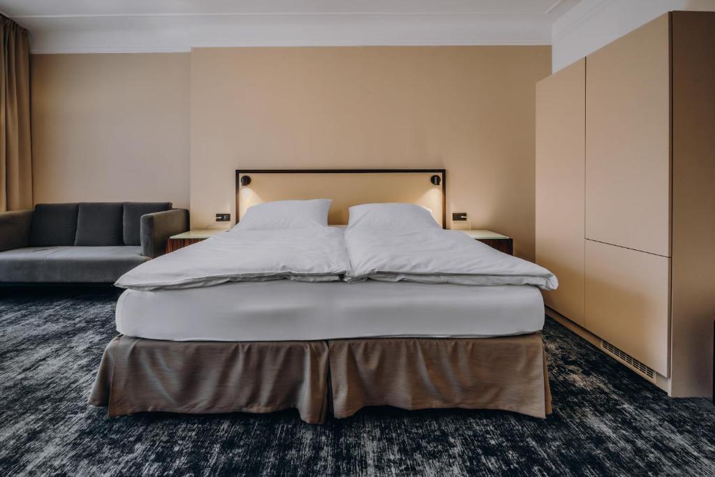 a bedroom with a large bed and a couch at Esplanade Carlsbad in Karlovy Vary