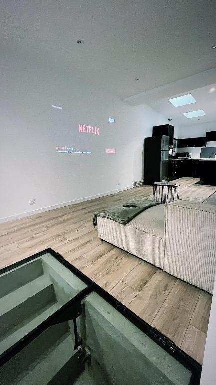 Cette chambre est dotée d'un lit et de parquet. dans l'établissement Grande Maison et Jardin Métropole, à Seclin
