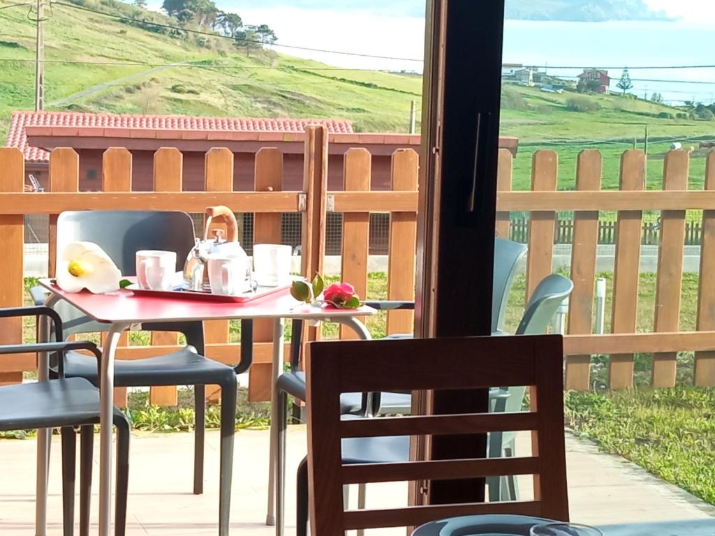 einen Tisch und Stühle auf einer Terrasse mit Aussicht in der Unterkunft Camping Playa de Nemiña in Nemiña