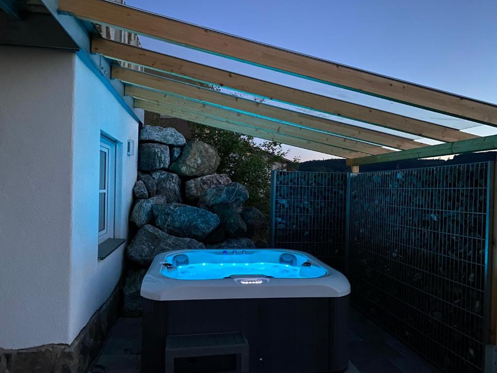 a hot tub sitting under a pergola next to a building at Allgäu-Chalet Kaufbeuren in Kaufbeuren
