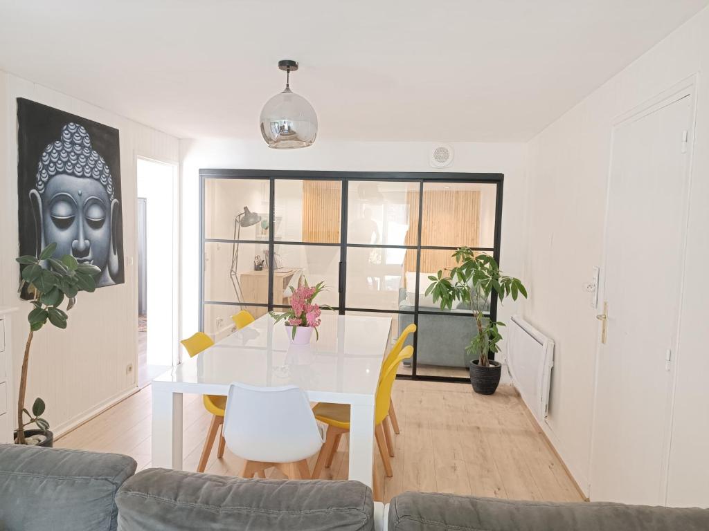 - un salon avec une table à manger blanche dans l'établissement Appartement de 85 m2 au cœur de Carnac plage, à Carnac