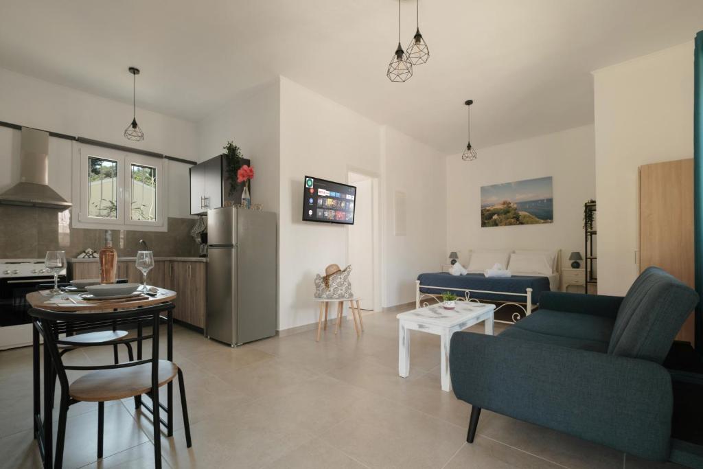a living room with a blue couch and a kitchen at Agatha's central bright modern luxury apartment-2 in Perítheia