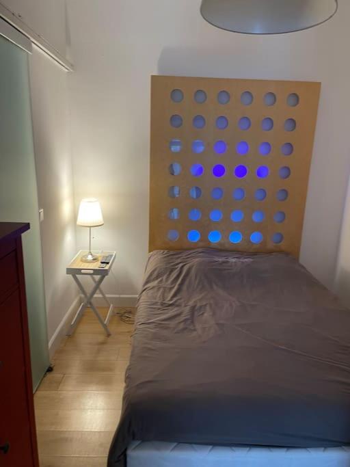 une chambre avec un lit et une table avec une lampe dans l'établissement Studio proche du Luxembourg, à Aumetz