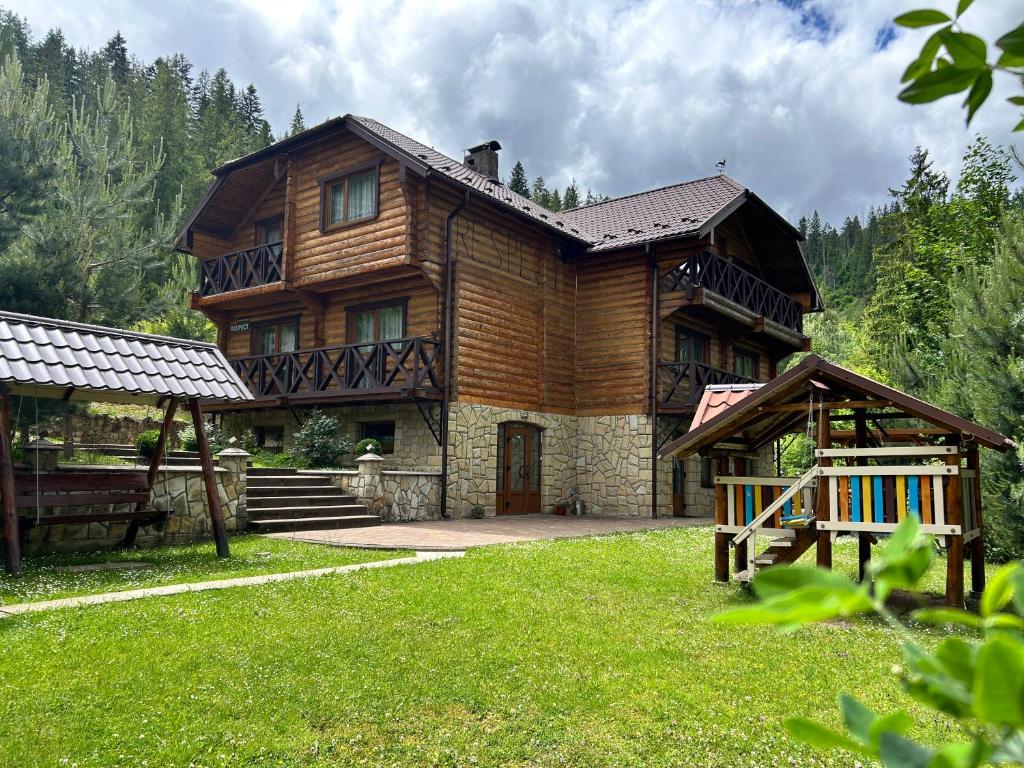 a large wooden house with a yard in front of it at Respect in Mykulychyn