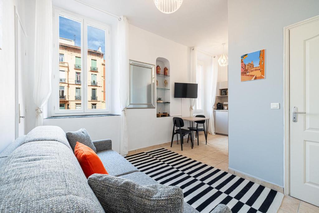 un salon avec un canapé et une table dans l'établissement FELIX FAURE - Charmant studio lumineux en centre-ville, à Menton